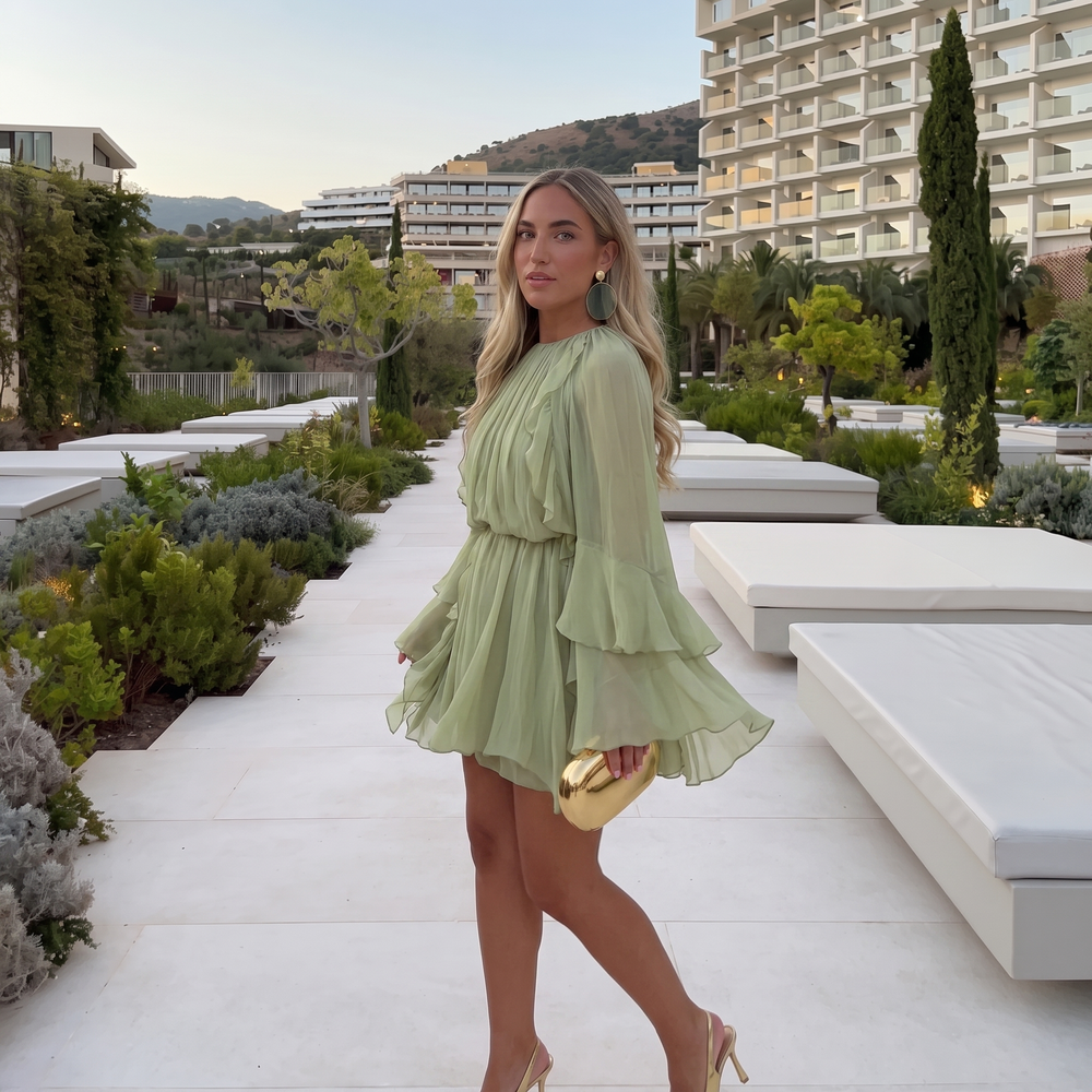 Woman wearing ruffled chiffon midi dress with flowing sleeves