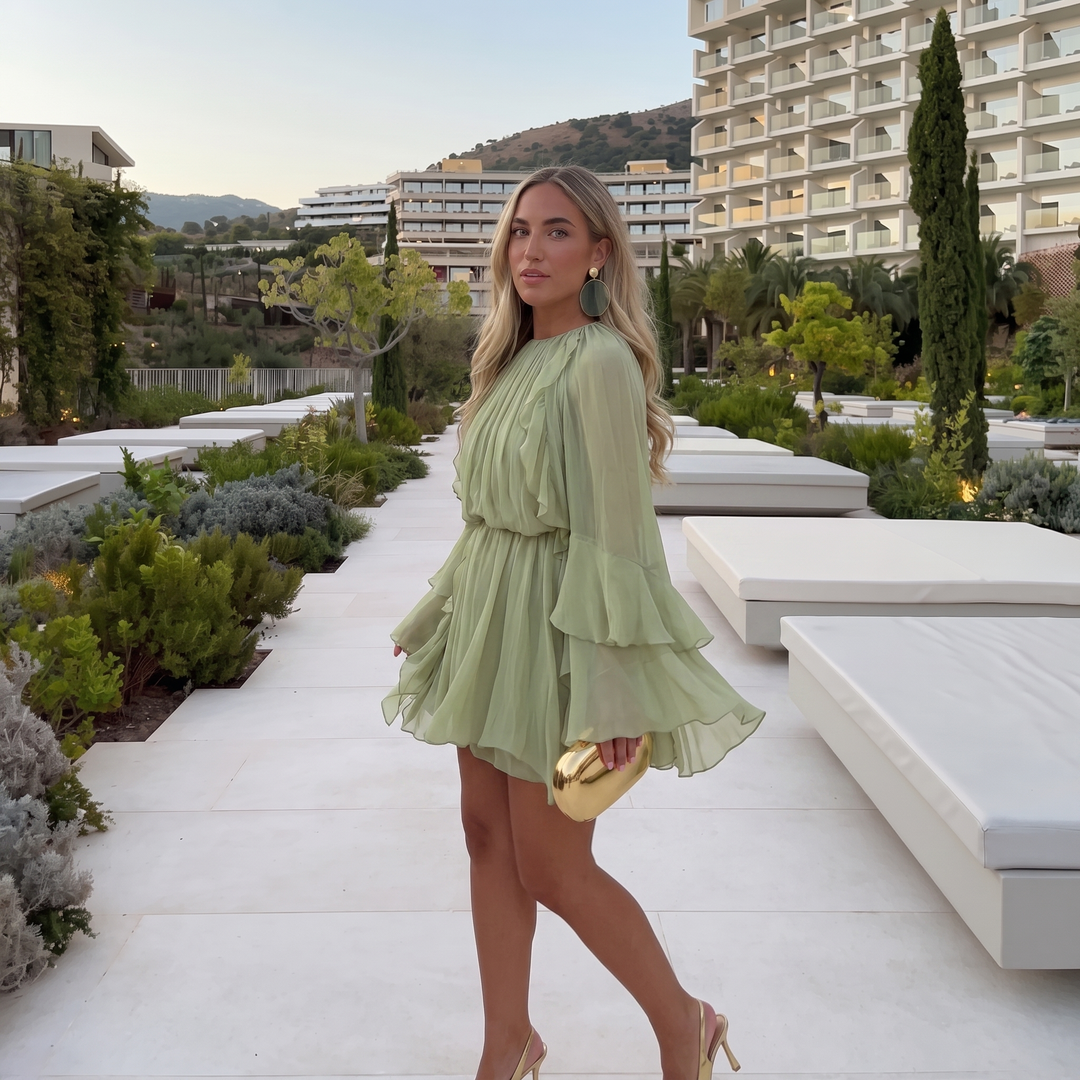 Woman wearing ruffled chiffon midi dress with flowing sleeves