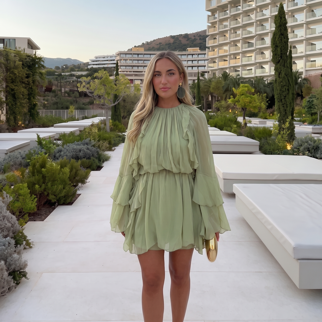 Woman wearing ruffled chiffon midi dress with flowing sleeves