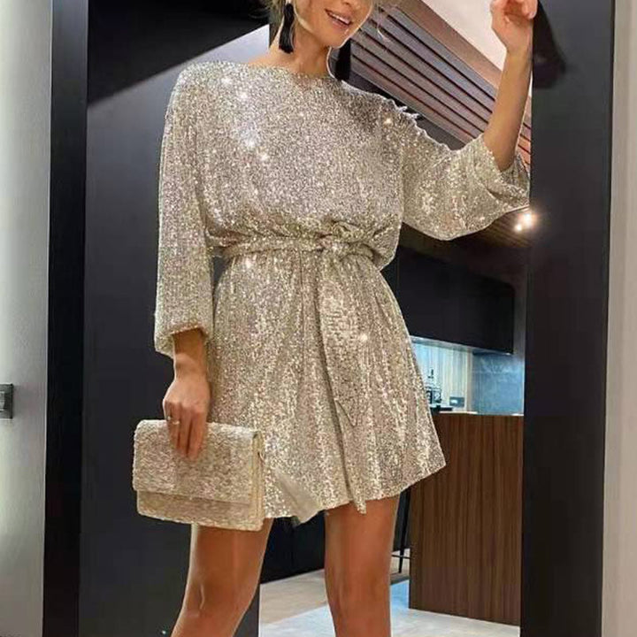 Woman wearing sparkling sequin mini dress with waist tie detail
