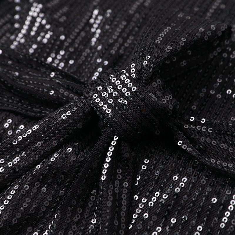 Woman wearing sparkling sequin mini dress with waist tie detail