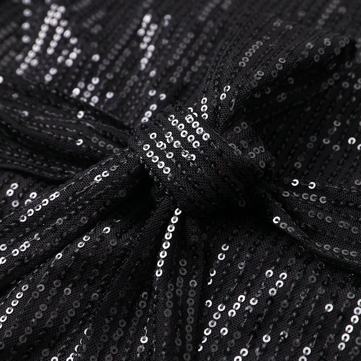 Woman wearing sparkling sequin mini dress with waist tie detail