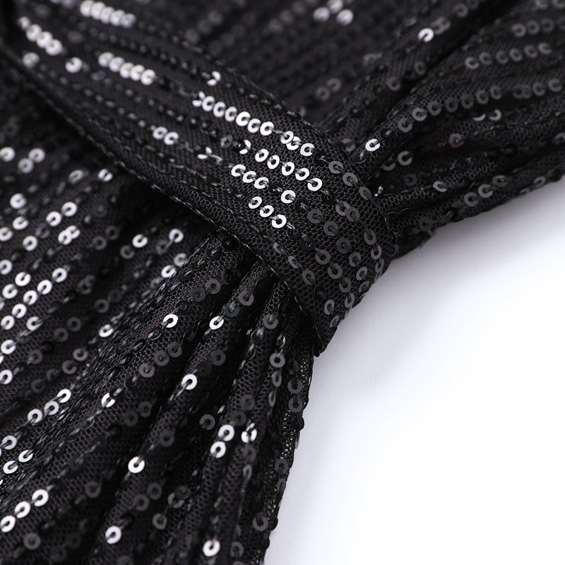 Woman wearing sparkling sequin mini dress with waist tie detail
