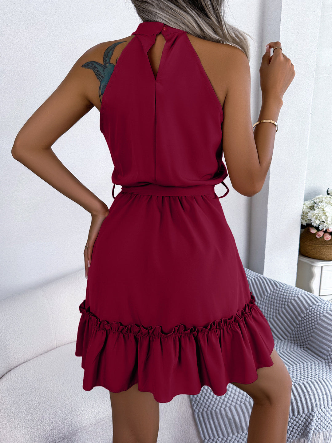 Woman wearing halter neck ruffle mini dress