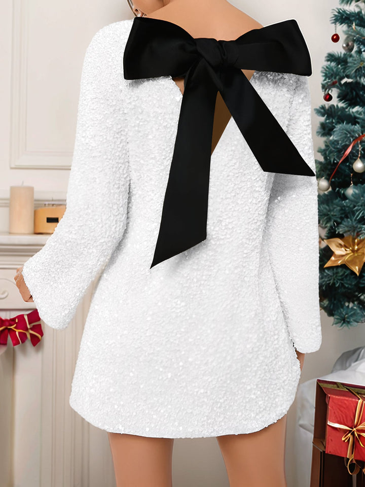 Ghislaine Miremont white sequin mini dress with a plain boat neckline, open bow back and flared bell cuffs
