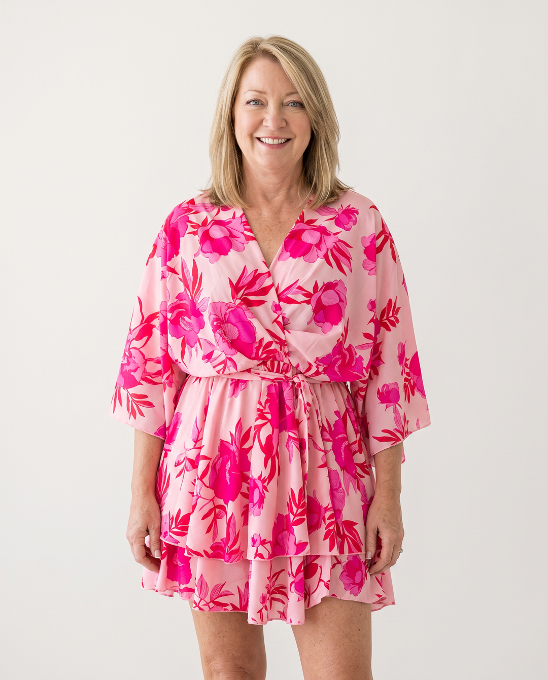 Woman wearing twist-front floral mini dress with layered ruffles