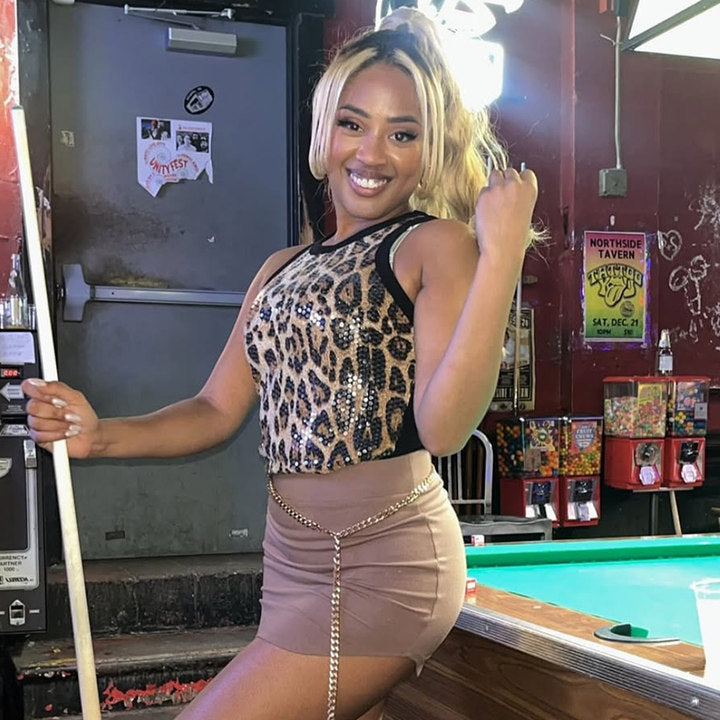 Model wearing the Sidonie Chapelain leopard print sequin halter tank top with a mini skirt and gold chain belt